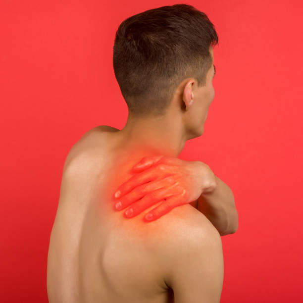 asian man suffering from pain in neck. symptom of cervical chondrosis. inflammation of vertebra, back view - inflammation back physical therapy isolated on white imagens e fotografias de stock