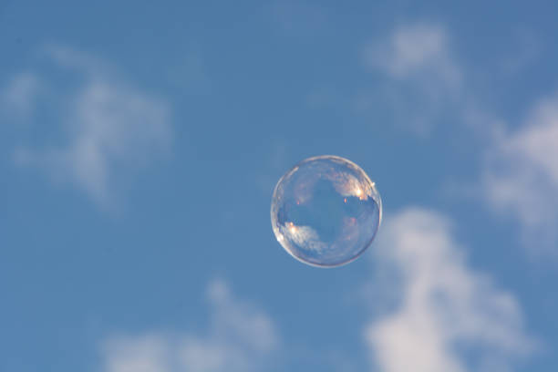 Clear blue sky filled with lot of soap bubbles that travel through the air. Shallow depth of field.