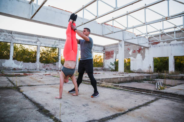 istock Personal trainer helping a woman do a handstand 1181637992