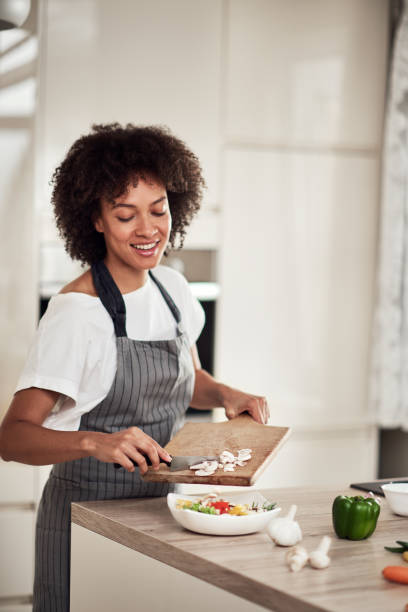 istock Woman putting mushrooms into bowl. 1181639042