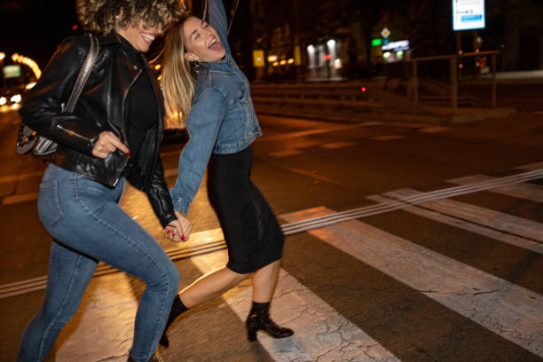 drunk female friends crossing the street - sensuality walking women beautiful imagens e fotografias de stock