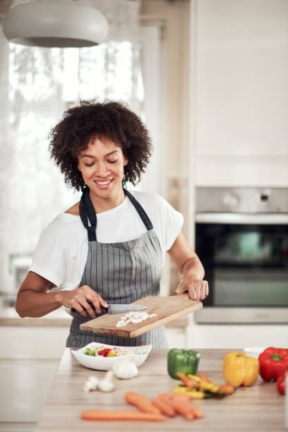 istock Woman putting mushrooms into bowl. 1181640023