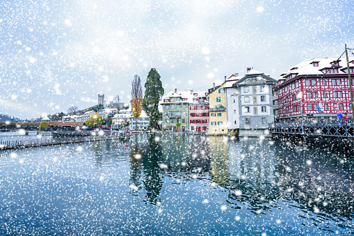 Snow falling over lucerne Reuss Switzerland lake water waves in the forground