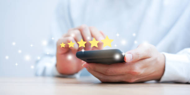 close up on customer man hand pressing on smartphone screen with gold five star rating feedback icon and press level excellent rank for giving best score point to review the service , technology business concept - rating ranking quality control aspirations imagens e fotografias de stock