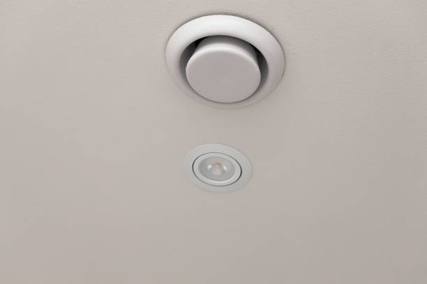 istock Close up view of white round ceiling vent. Building construction elements. Ventilation and Heating concept. 1181648930