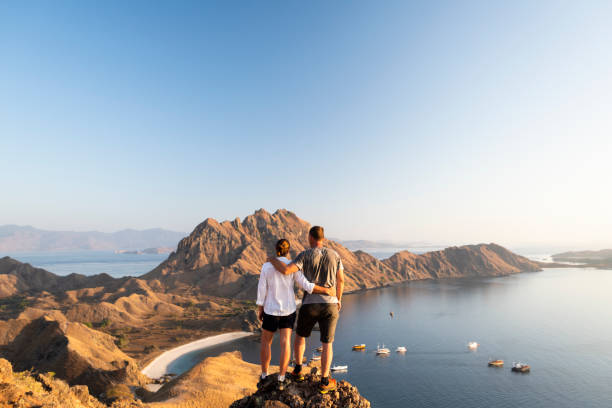 widok z tyłu pary patrząc na widok na tropikalne wyspy - sunrise beach couple hiking zdjęcia i obrazy z banku zdjęć