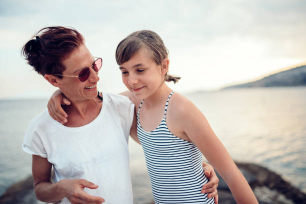 istock Mother and daughter having fun on the beach 1181651925