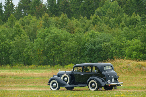 Falköping, Sweden - July 29, 2017:  Black classic Oldsmobile from 1934 driving in the rain