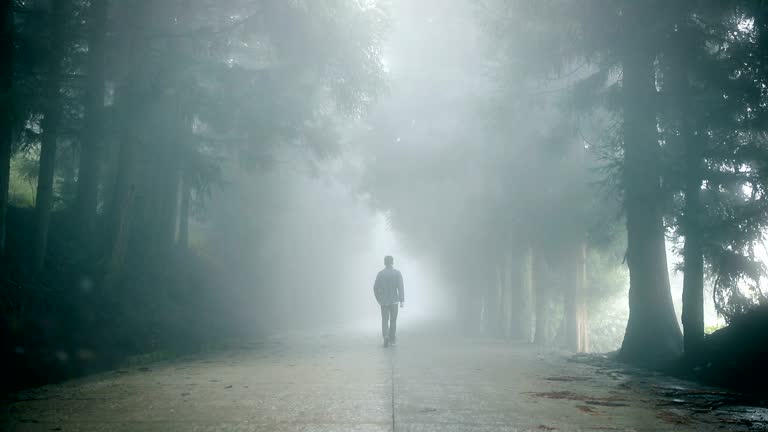 Man walking alone on foggy road