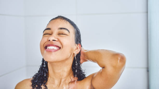 Cleansing my mind and body in warm waters Shot of an attractive young woman taking a shower inside her bathroom at home wet hair stock pictures, royalty-free photos & images