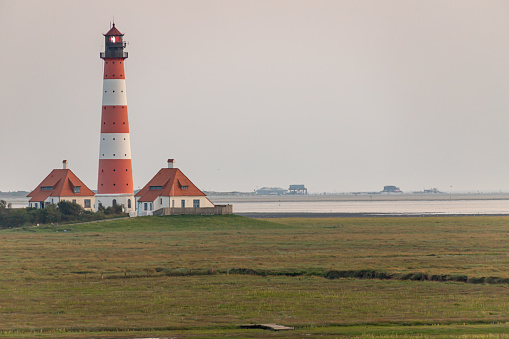 Lighthouse Westerheversand with stilt houses in the background