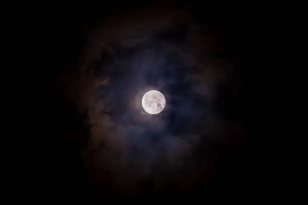 Photo of Full moon black background with clouds detail surface