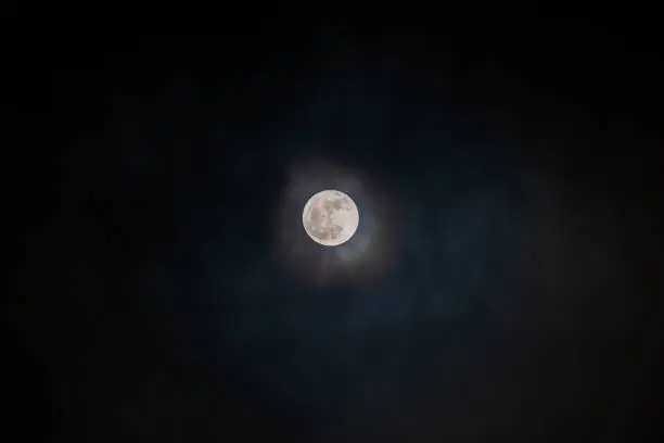 Photo of Full moon black background with clouds detail surface