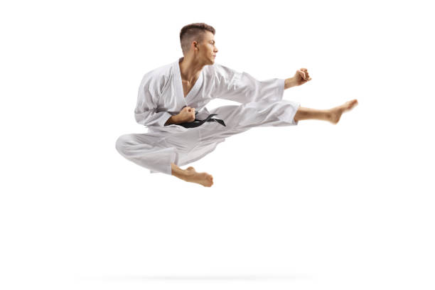 istock Young man in karate kimono jumping and kicking 1181655831
