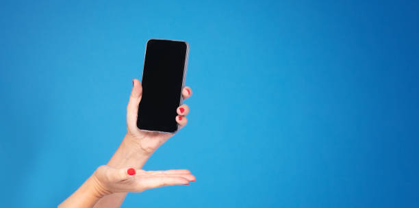 istock Hand with mobile phone on blue background. 1181659752
