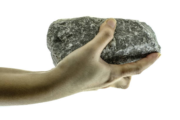 o fim acima da mão está prendendo a pedra isolada no fundo branco - throwing stone human hand rock - fotografias e filmes do acervo