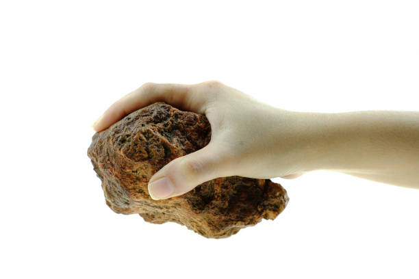 istock Close up hand is holding stone isolated at white background 1181660998