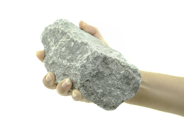 istock Close up hand is holding stone isolated at white background 1181661005