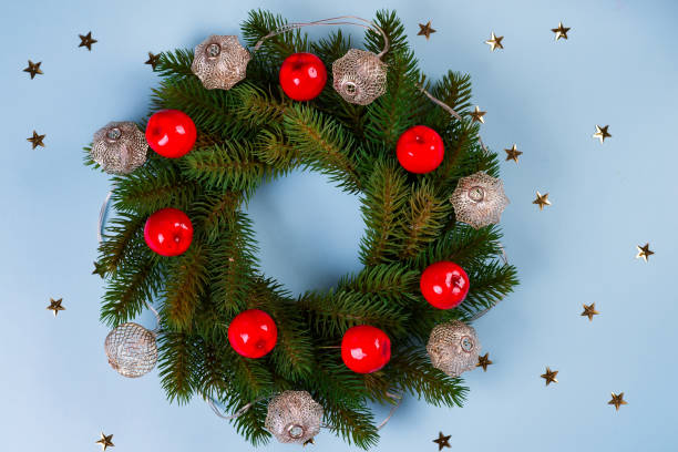 istock Rustic Christmas wreath with decorations on stars blue paper backround, flat lay 1181663625