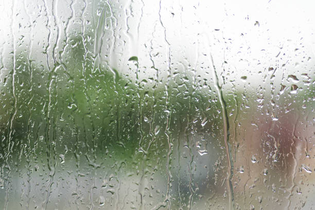 istock Rain drops on the window with green over background 1181664829