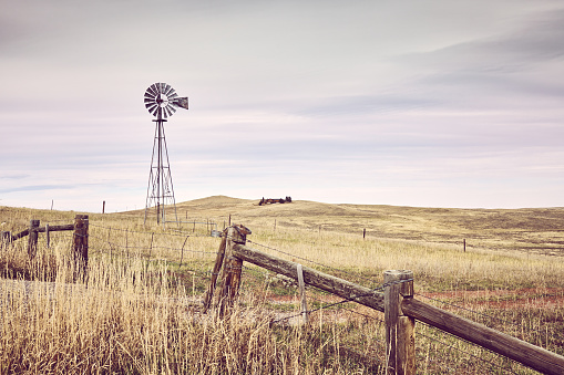 American countryside with an old windmill tower, color toning applied, USA.