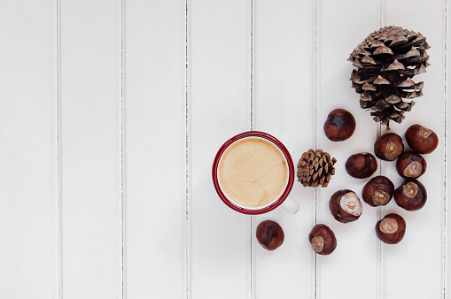 Fresh chestnuts with coffee on wood