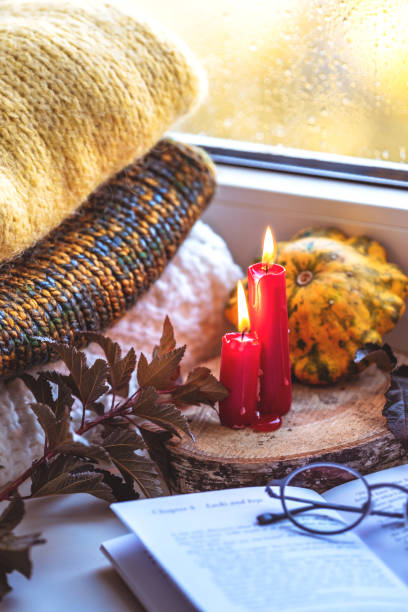 istock Autumn composition on a windowsill reading a book on a rainy evening. 1181667939