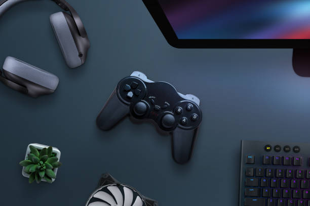 istock Joypad on desk surrounded with headphones, cooler, keyboard and computer display. PC gaming concept. Top view, flat lay. 1181670545