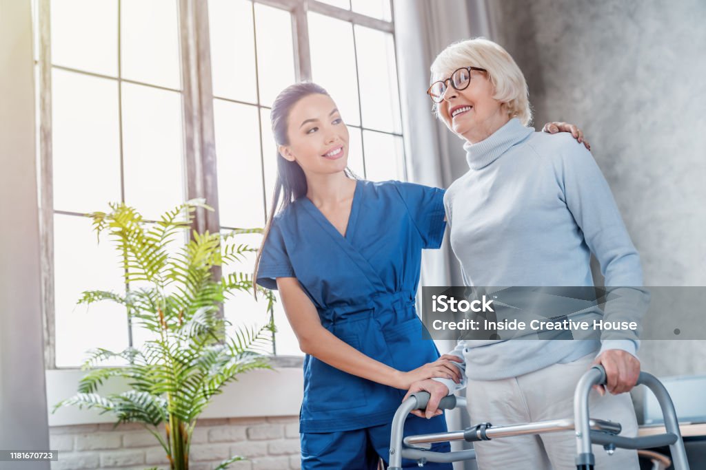 Female asian nurse helping senior woman to walk with walker at home Senior Adult, Nurse, Patient, Care, Assistance Nurse Stock Photo