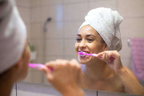 istock Woman brushing teeth in bathroom 1181670915
