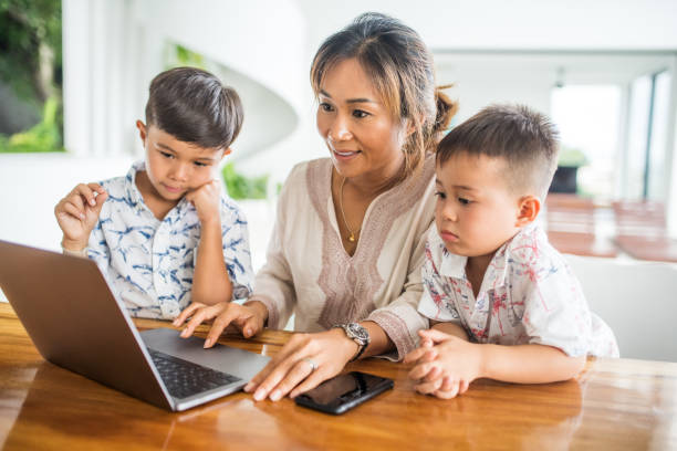 istock Thai family using technology in their everyday live. Playing with laptop. 1181672031