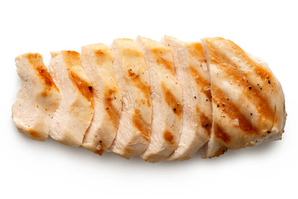 partially sliced grilled chicken breast with grill marks, ground black pepper and salt isolated on white. top view. - chicken breast imagens e fotografias de stock