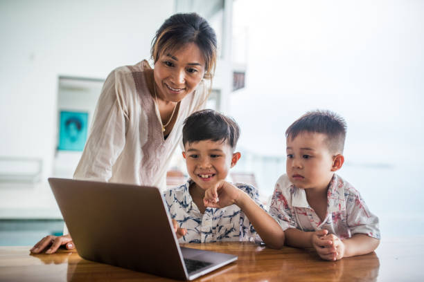 istock Thai family using technology in their everyday live. Playing with laptop. 1181674424