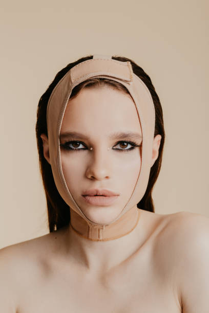 istock Woman after plastic surgery wearing face bandage 1181674510