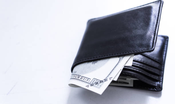 istock A black leather wallet with money inside on the white table. Money concept, copy space for text. 1181674551
