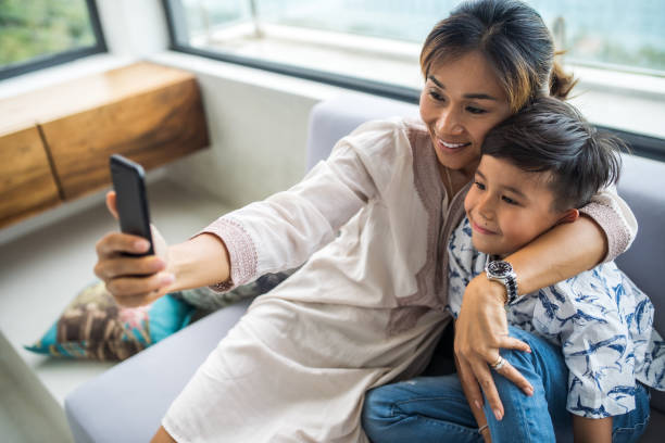 istock Thai family using technology in their everyday live. Taking selfies. 1181675582