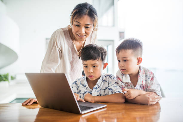 istock Thai family using technology in their everyday live. Playing with laptop. 1181675748