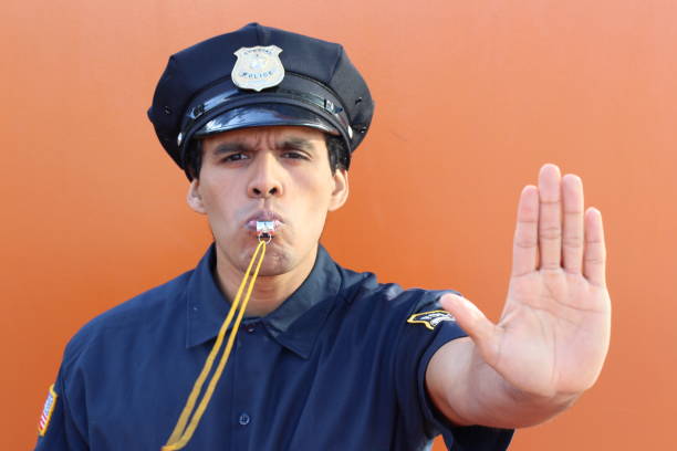 istock Policeman blowing whistle and showing stop hand gesture 1181676616