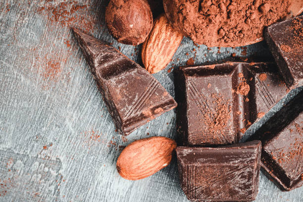 istock Chocolate cubes, brown cocoa powder in the spoon and nuts, top view 1181679942