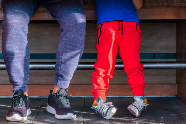 Legs of father and son under the table Legs of father and son under the table jogging pants stock pictures, royalty-free photos & images