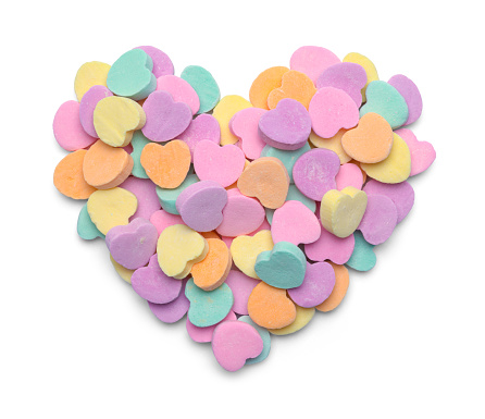 Pile of Valentine Candy Hearts in Heart Shape Isolated on White.