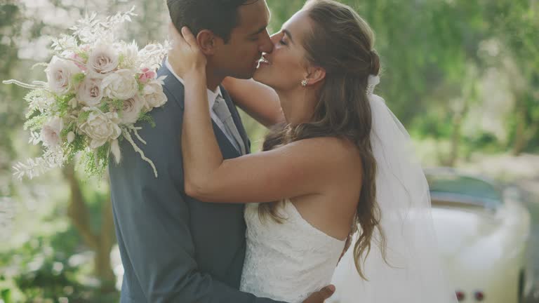 Happy newly wed couple kissing in nature