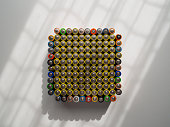 A large number of old AA batteries of different colors. Batteries laid out in a square shape.