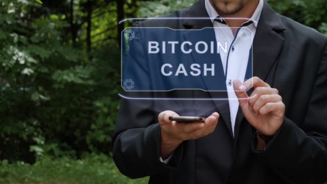 Businessman uses hologram with text Bitcoin cash