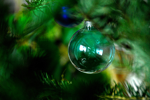 Green christmas bauble hanging on christmas tree