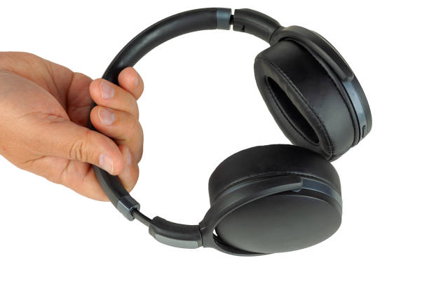 istock Hand holds wireless headphones on a white background. Isolate. 1181688107