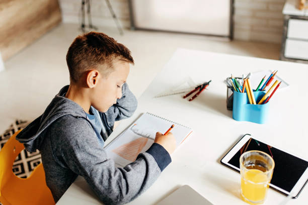 istock Little boy doing homework at home 1181689163