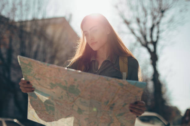 istock Woman tourist exploring city while holding map 1181689493