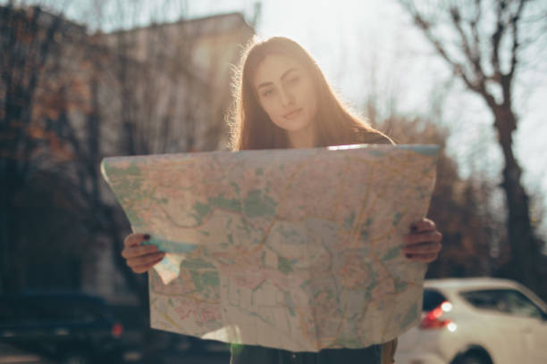 istock Woman tourist exploring city while holding map 1181689592