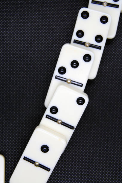 istock White marble dominoes on a black color background. 1181689650
